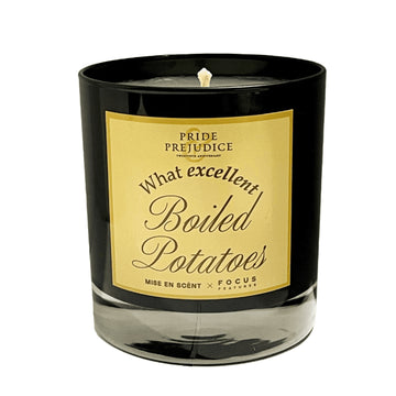 Candle with a black holder and gold label featuring text, on a white background. Pride & Prejudice movie 20th Anniversary collecible gift item  scented aroma candle Focus Features Academy Museum Store.